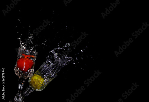 Tomato and lemon splashing into clear water on Black background, splash healthy food diet freshness concept.