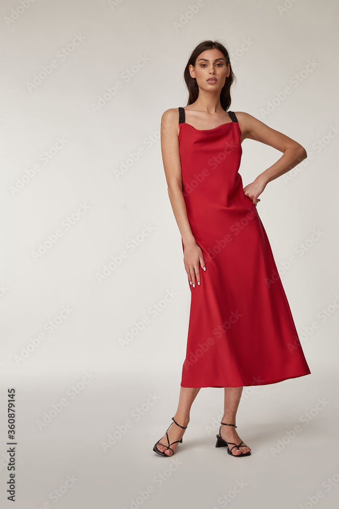 Fashion pretty woman beautiful makeup perfect body shape tanned skin wear clothes summer collection organic textile red silk long dress trendy sandals shoes, accessory style for romantic date walk. Fashion pretty woman beautiful makeup perfect body shape tanned skin wear clothes summer collection organic textile red silk long dress trendy sandals shoes, accessory style for romantic date walk.