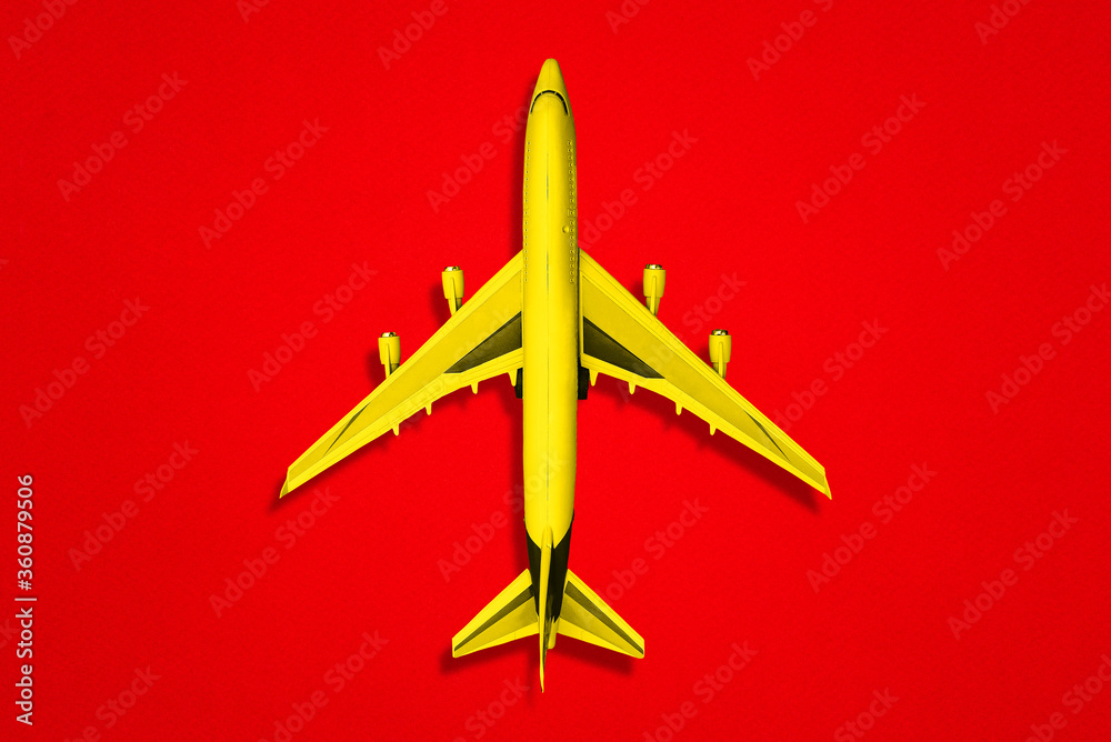 Yellow plane on a red background. A top view of a flat layout. Yellow plane on a red background. A top view of a flat layout.