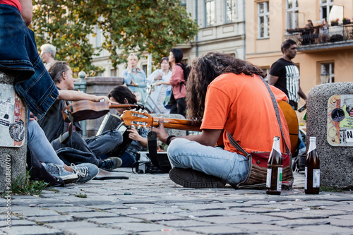 Homeless musician playing guitar, busking in the street photo