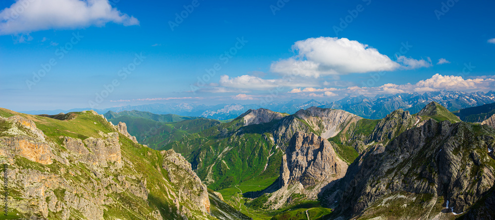 Mountain landscape on the Alps, rocky mountains at high altitude, moody sky green valley and hiking paths for tourism summer vacation Mountain landscape on the Alps, rocky mountains at high altitude, moody sky green valley and hiking paths for tourism summer vacation