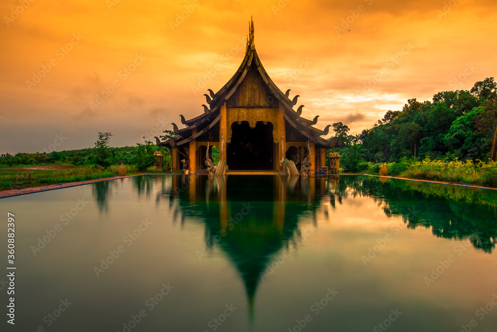 The background of the Wat Pa Kham Charoen is a beautiful old church with a Buddhist statue and a tree-lined temple, with tourists and travelers always making merit in Udon Thani, Thailand.