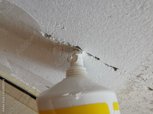 How to repair a wall. Wall with cracks. fill cracks with a spatula filler and repair kit. Wandrisse richtig reparieren. Tube an die Wand halten.