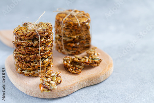Stacks of healthy eco sweets with different seeds and honey on wooden board