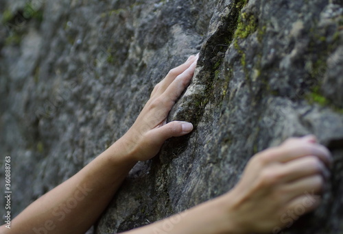 Girls hands grabbing a rock while climbing