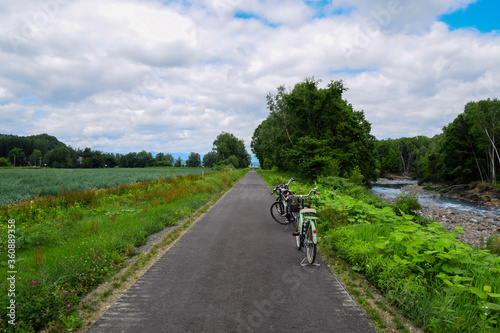 Bicycle lane along onion farm and Biei river in Hokkaido, Japan.