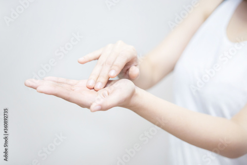 Asian Woman Applying Moisturizer on Her Hand