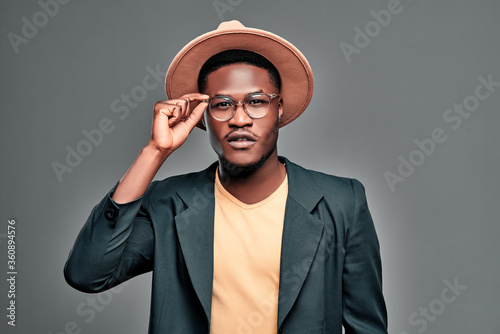 Portrait of black man with beard wearing in T-shirt and jacket, hat and glasses. photo