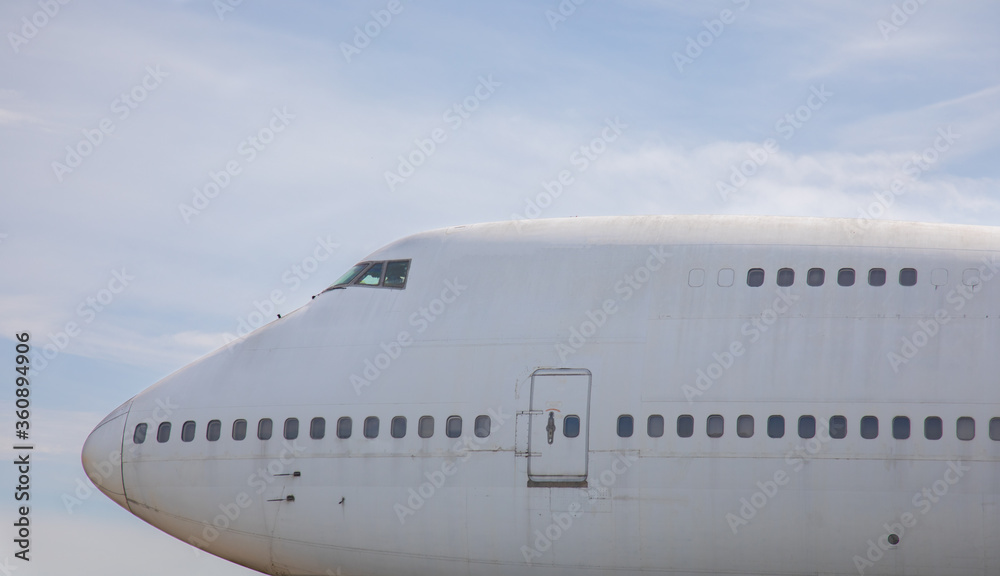 Close-up and high-view shot of airplane's head part is under beautiful blue sky background  which has been used for flight service for long time showing water stain and rust on the metal surface.