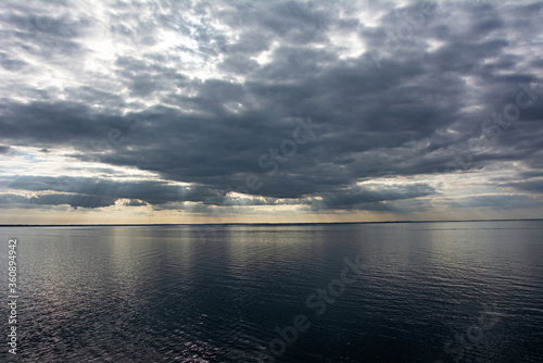 Dark clouds and sun rays in the evening over the Baltic Sea.