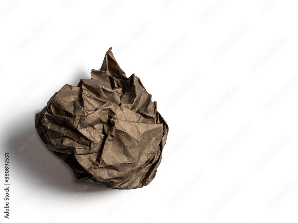 a ball of crumpled brown paper isolated on a light background.