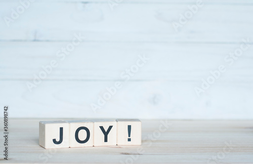 The word Joy on a wooden cube. Letter constructor