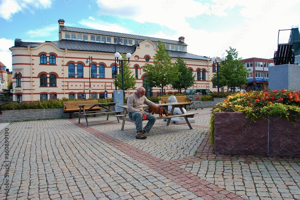  Vastervik, Sweden, city center man with dachshund on the park bench
