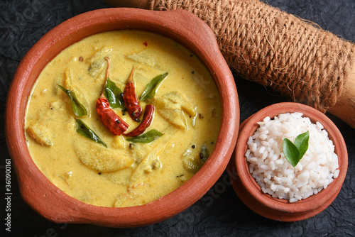 Traditional yellow mango curry or Mampazha Pulissery sweet and sour dish Kerala India . Made from organic raw ripe mango, coconut milk, seasoned with curry leaves, mustard, Indian red Kashmir chilli. photo