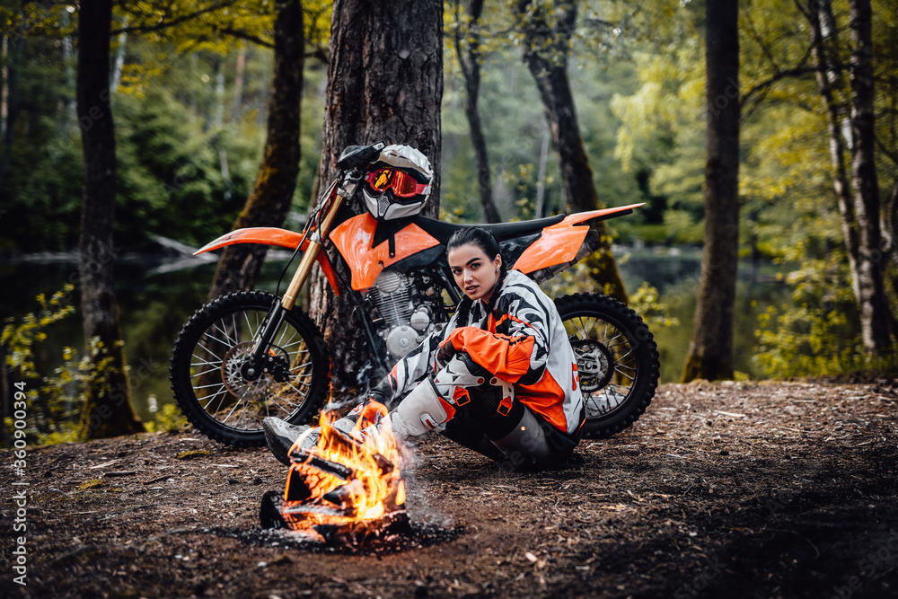Φωτογραφία Young female motocross racer wearing motorcycle outfit, relaxing and warming nex