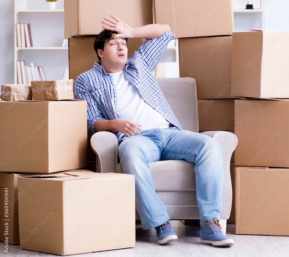 Young man moving in to new house with boxes Young man moving in to new house with boxes