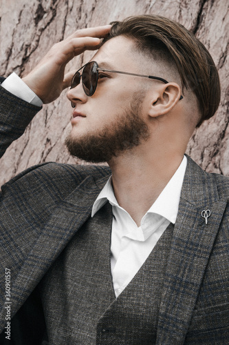 A man in a classic suit. In the sunglasses. In profile. Light background