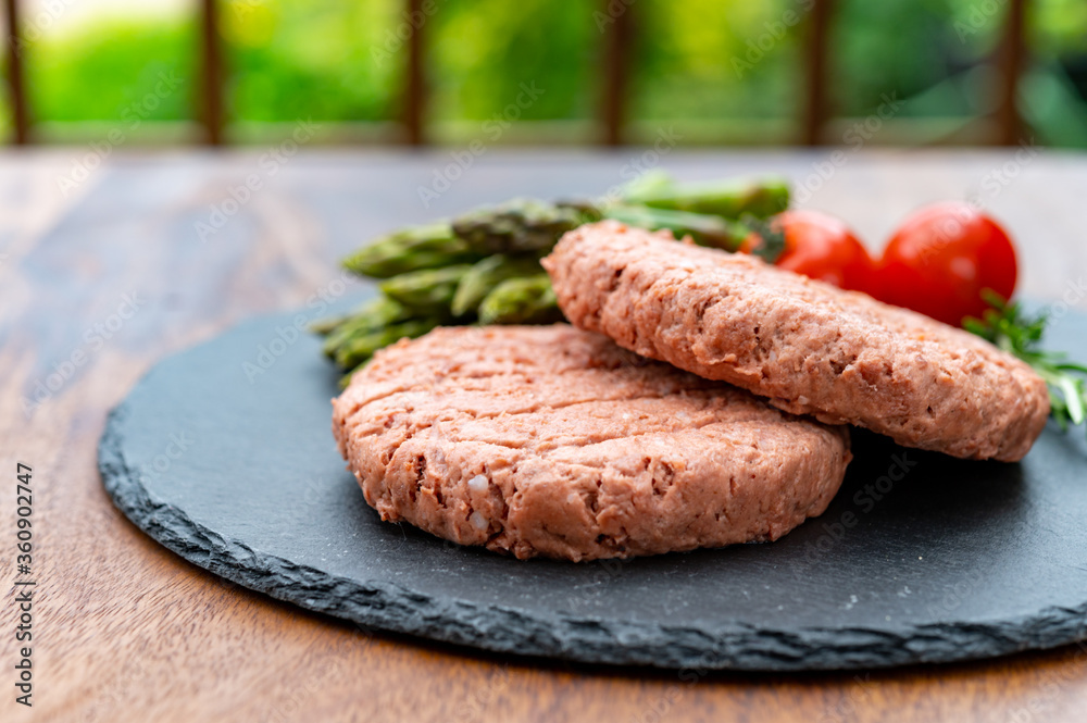 Ingredients for tasty vegan dinner, meat free plants based steak, green asparagus and red tomatoes Ingredients for tasty vegan dinner, meat free plants based steak, green asparagus and red tomatoes