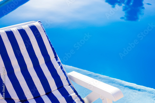 Hamaca con lineas azules y blancas en piscina en tarde de verano