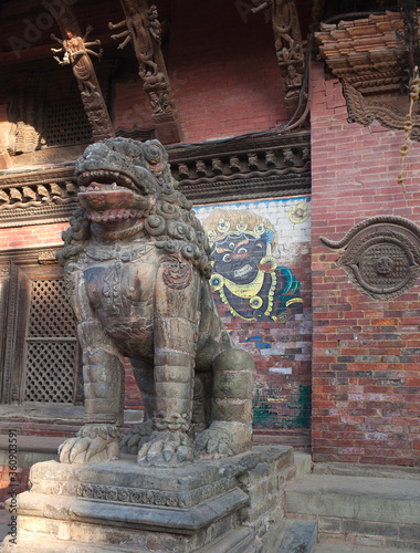 Ancient statue of Lion guards the entrance to the Palace at Durbar Square in Patan, Kathmandu Valley, Nepal photo