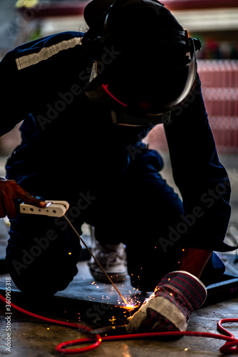 Industrial Worker labourer at the factory welding steel structure