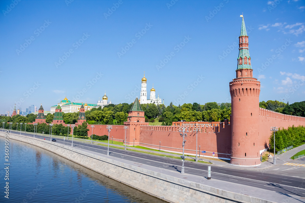 Cityscape of Moscow city near Moscow Kremlin made from red bricks with green trees and few orthodox churches on a summer morning. Clear blue sky. Theme of travel in Russia.