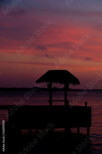Pink violet Maldivian sunset under the ocean pavilion
