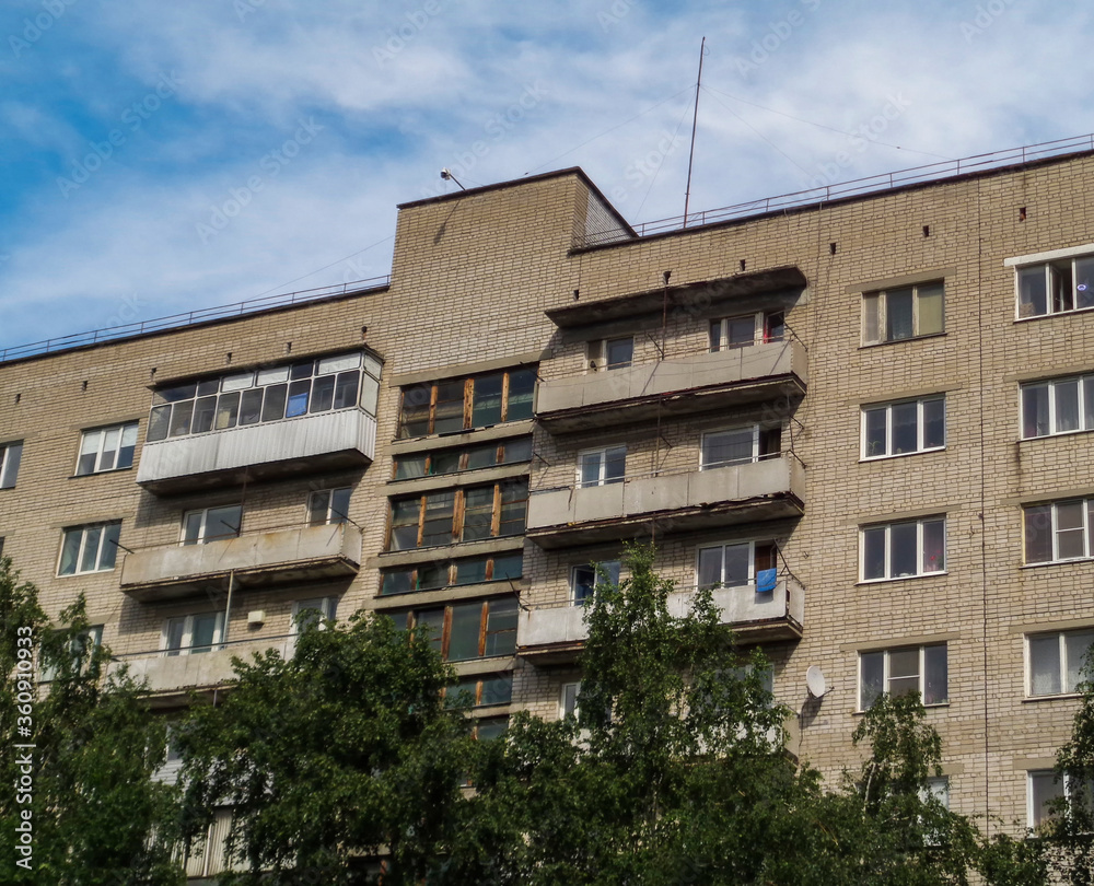 Soviet apartment building. Apartment block. Soviet architecture. Green trees. Blue sky Soviet apartment building. Apartment block. Soviet architecture. Green trees. Blue sky