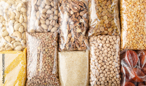 Flat lay view at plastic containres with non-perishable foods on kitchen table photo