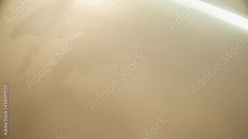 A fogged mirror in the shower room. Male hand