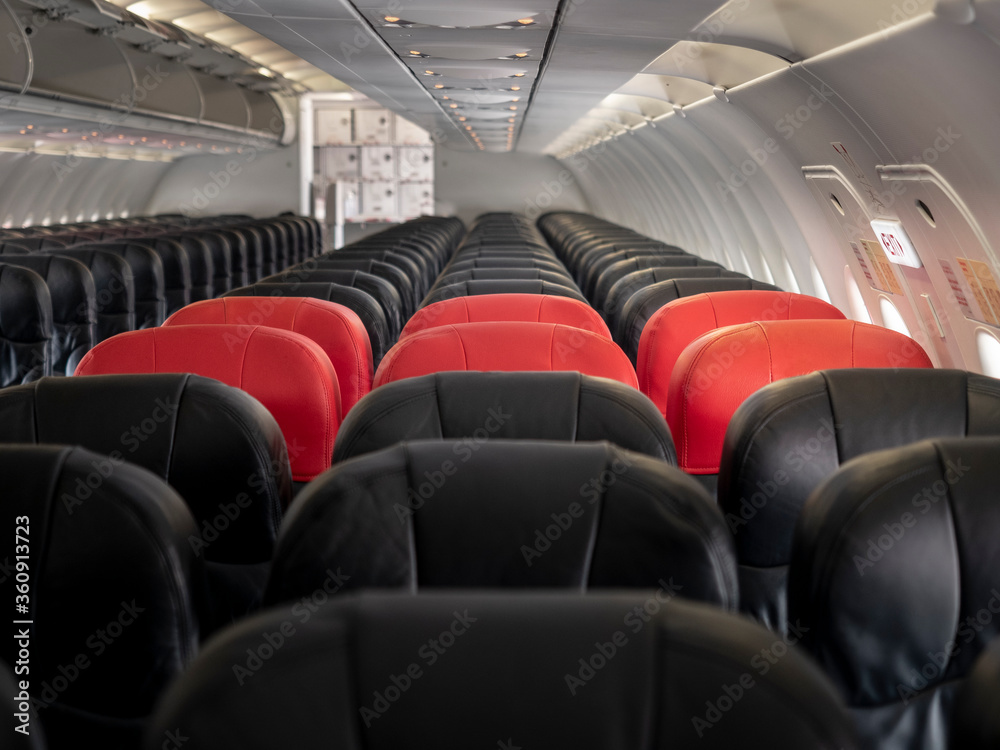 Fototapeta premium premium and economy seat row in cabin. red and black seat. Outstanding red premium seat among economy.