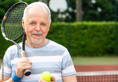 An active pensioner, portrait of senior man playing tennis in outside, retired sports, sport concept © Khaligo