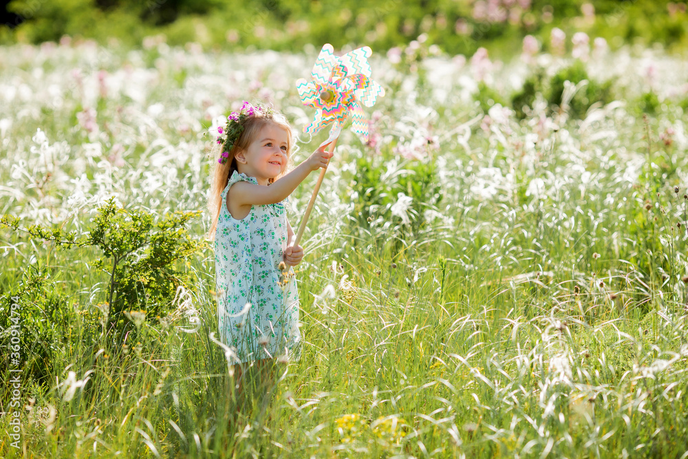 Fototapeta premium Cute little girl smiling summer in the field holding a baby tinge