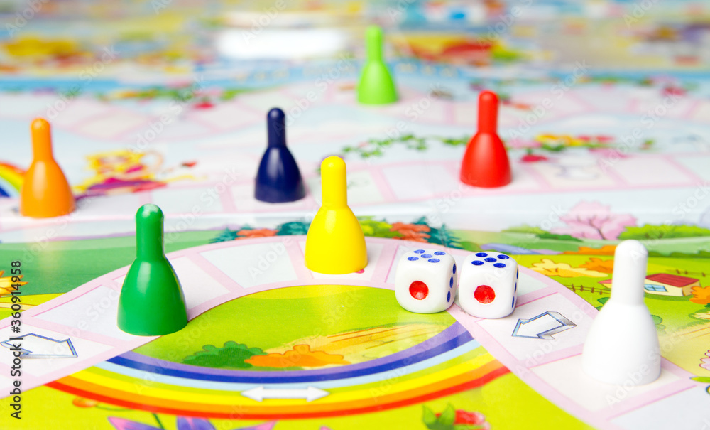 Naklejka premium Board games for the home. Yellow, green, blue, red plastic chips and dice on Board games for children . Selective focus