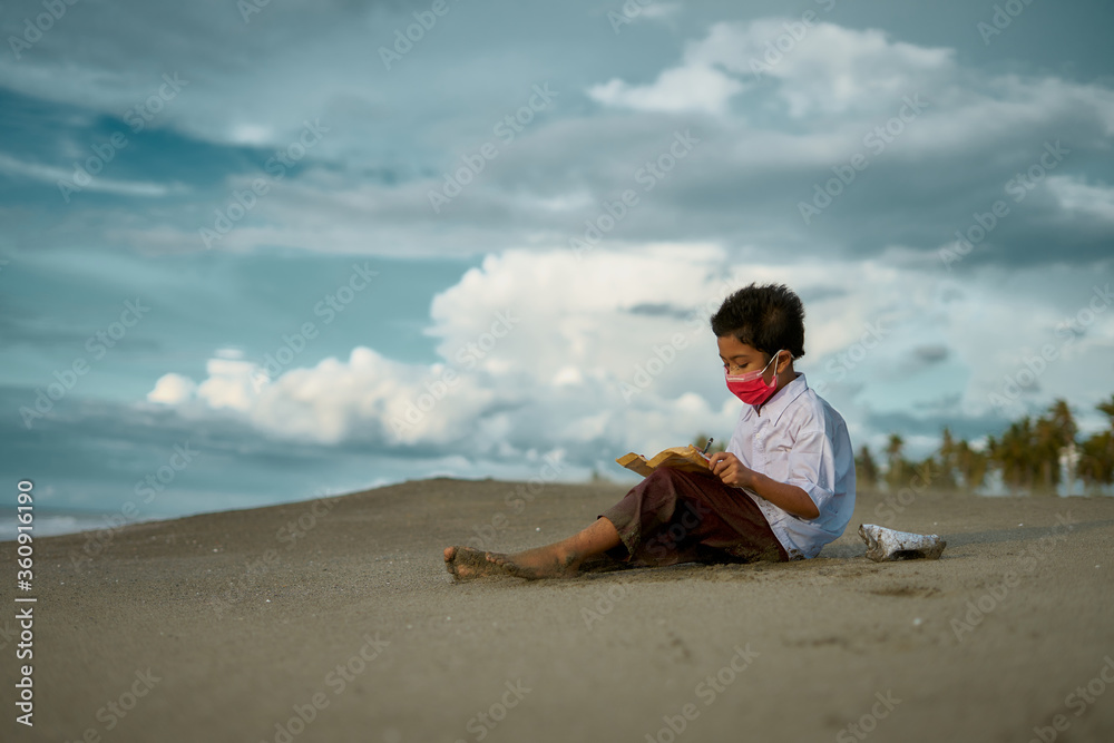 Little boy study hard, doing homework outdoor under cloud and blue sky. Homeschooling,  New normal - concept
