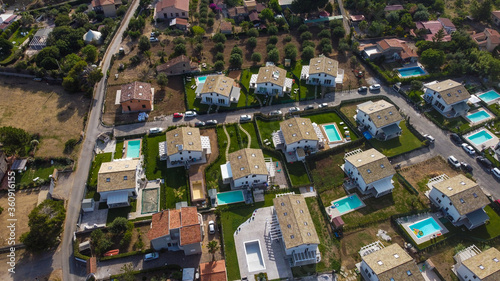 Aerial view of the Villa in Campofelice di Roccella in Sicily, under a beautiful sunny sky, with swimming pools and trees.