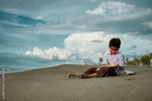 Little boy study hard, doing homework outdoor under cloud and blue sky. Homeschooling, New normal - concept