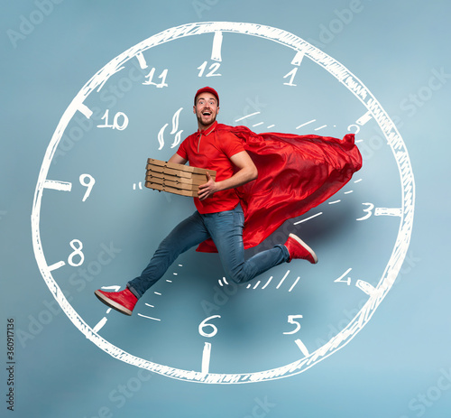 Deliveryman with pizzas acts like a powerful superhero. Concept of rapidity and guarantee on shipment. Studio cyan background photo