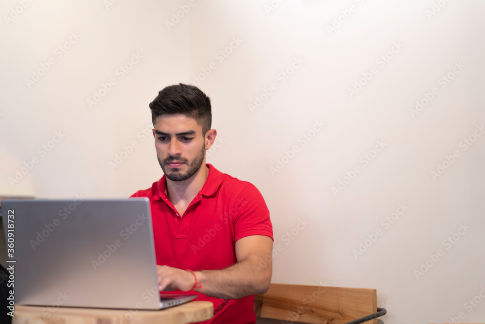 young man working with his laptop in a coffee shop young man working with his laptop in a coffee shop