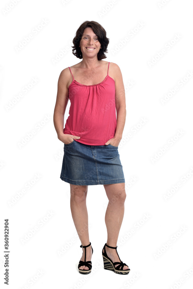 woman in a denim skirt on white background, hands on pocket woman in a denim skirt on white background, hands on pocket