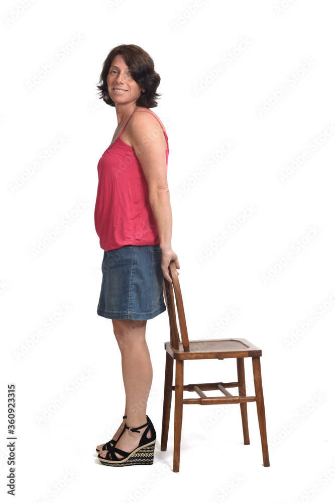  woman in denim skirt playing with a chair on white background,