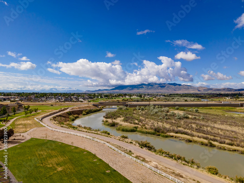 Aerial view of a bike trail along a river with mountains in the distance