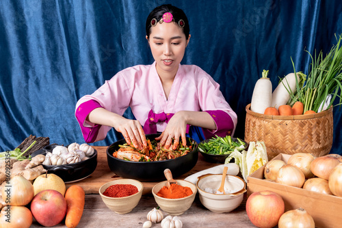 Photography Korean woman is wearing a traditional hanbok, she making Kimchi which is a ferme