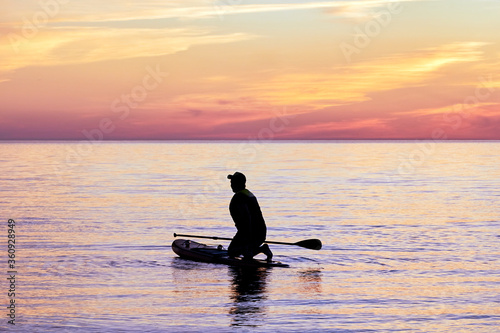 silhouette of a man with a surfboard