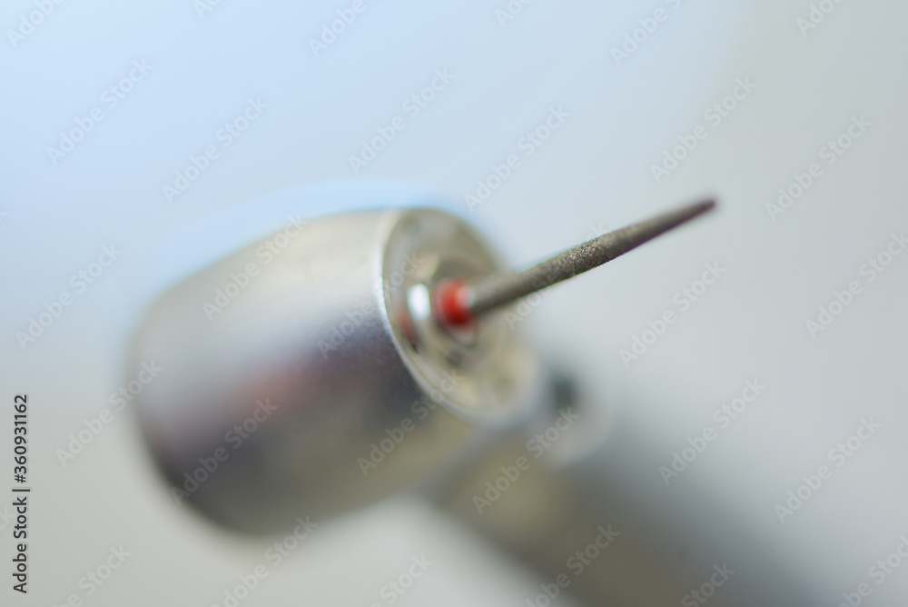 A close photo of a dental diamond bur in the turbine stainless handpiece. A close photo of a dental diamond bur in the turbine stainless handpiece.