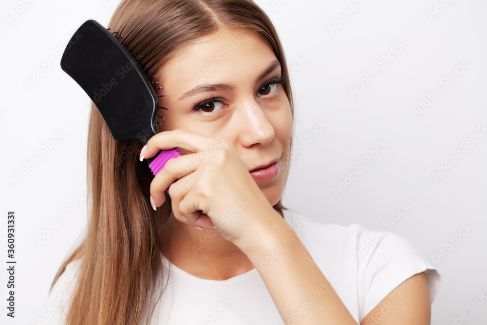 Young female model with beautiful long hair combs his comb Young female model with beautiful long hair combs his comb