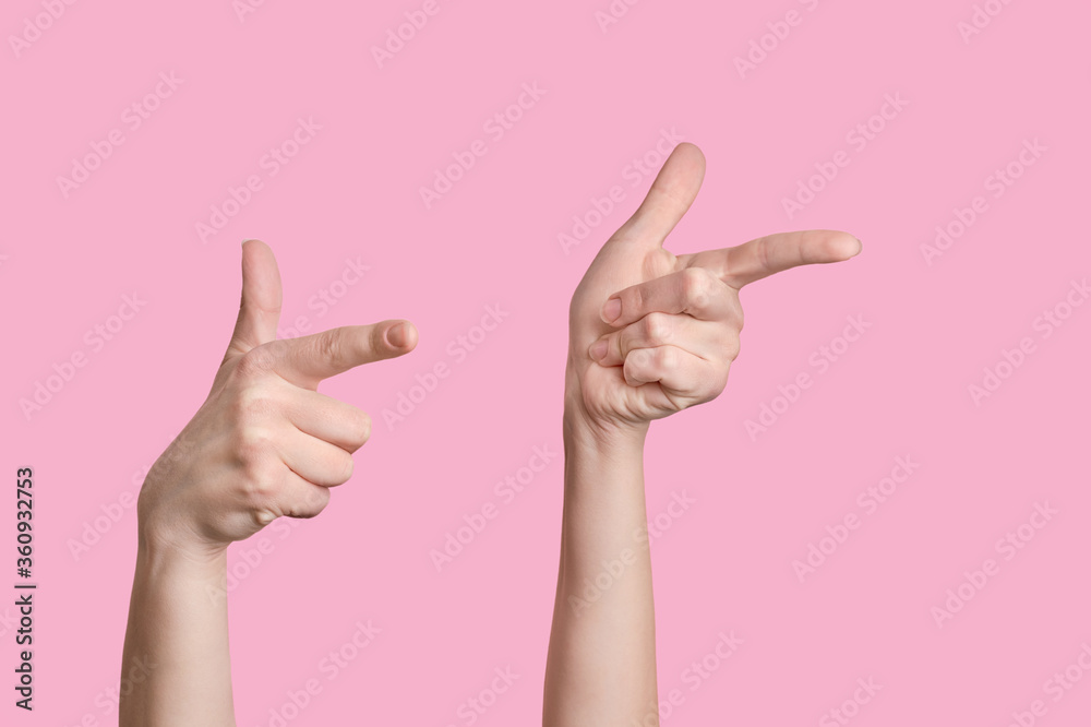 Two Caucasian hands indicate the direction to the right. Pink background.