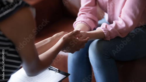 African psychologist hold hands of girl patient, close up. Teenage overcome break up, unrequited love. Abortion decision. Psychological therapy, survive personal crisis, individual counselling concept photo