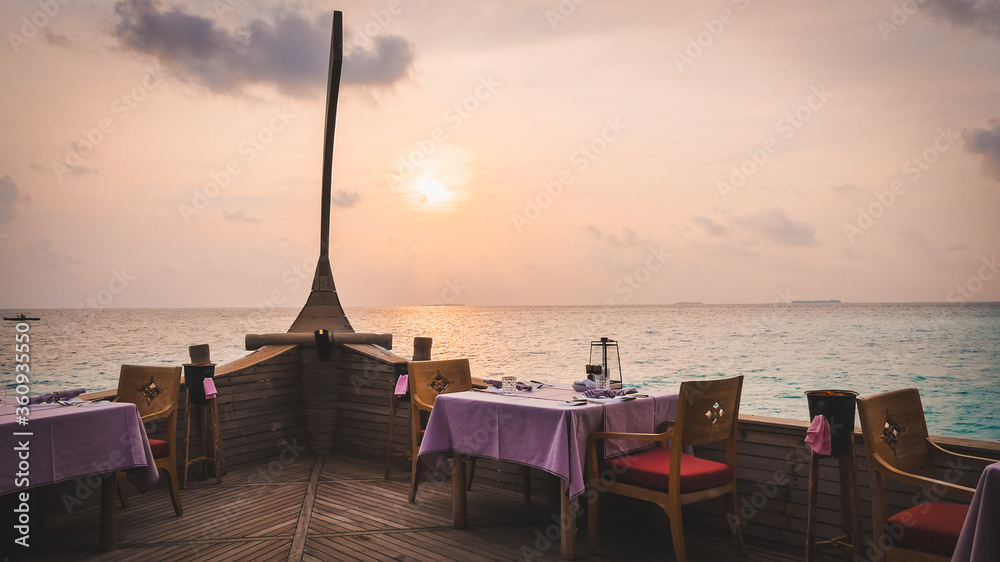 Tisch in einem Restaurant auf den Malediven bei Sonnenuntergang Tisch in einem Restaurant auf den Malediven bei Sonnenuntergang