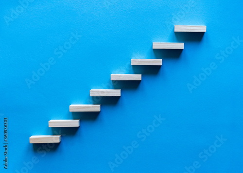 Wooden pegs forming a stairway. Wooden stairs elevate promotion of the business. Business promotion stairs to heaven. stairs to the blue sky. Wooden stairs. Business start up. Promotion and elevation